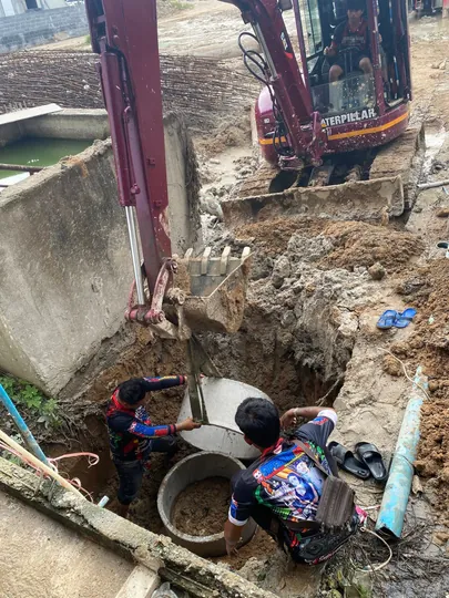 Excavator digging trench for pipes and utilities on Koh Samui