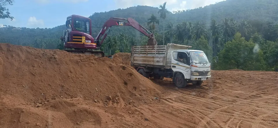 Dump truck delivering soil and bulk materials to a construction site on Koh Samui