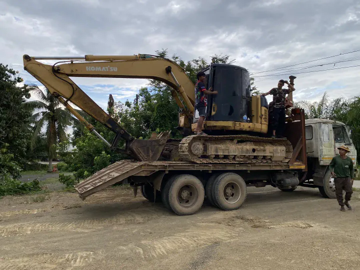 Transporting an excavator by lowbed trailer between construction sites on Koh Samui